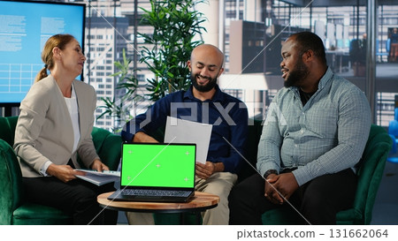 CEO and executive team conducting research next to green screen in a corporate environment, developing strategy and sharing expertise to drive company investment and performance. Camera A. 131662064