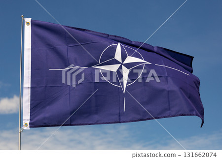 Dark blue flag of NATO waving against clear sky Dark blue flag of NATO waving against clear sky 131662074