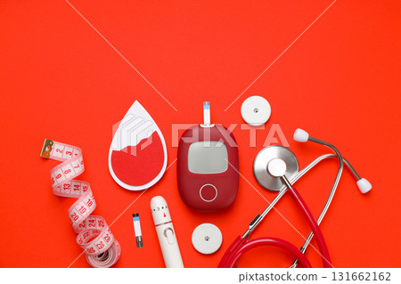 Diabetes management tools arranged on a bright orange background 131662162