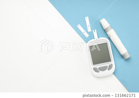 Blood glucose meter with test strips on a blue and white surface 131662171