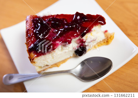 Pieces of cranberry cheesecake tart on wooden table. 131662211