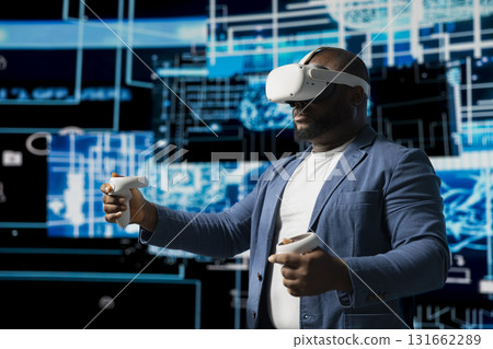 Black IT technician working on deep learning with virtual reality headset, implementing AI models and data visualization systems via neural networks. Programming and cloud computing. 131662289