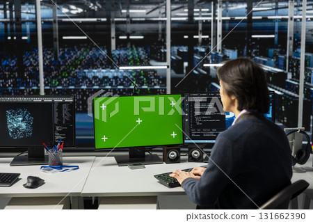 Data center technician using chroma key computer, working on databases supporting AI apps. Server room IT expert using artificial intelligence tech on isolated screen PC to do algorithms improvements 131662390