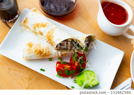 Delicious lula-kebab in lavash with vegetables and herbs 131662560