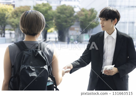 A man in a suit handing out tissues 131663515