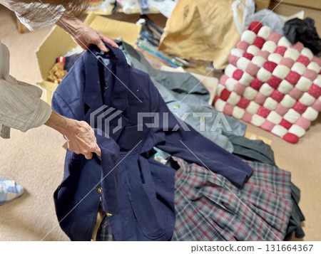Hands of an elderly woman holding a female student's uniform 131664367