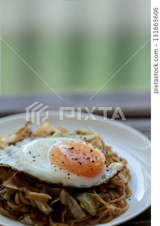 Medium-thick yakisoba noodles topped with a fried egg Medium-thick yakisoba noodles topped with a fried egg 131665606
