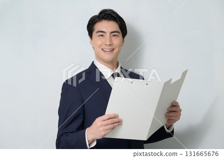 白色背景下手持剪貼簿的男人看著相機 131665676