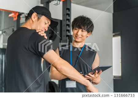 一名男教練在私人健身房為會員提供個人指導 131666733