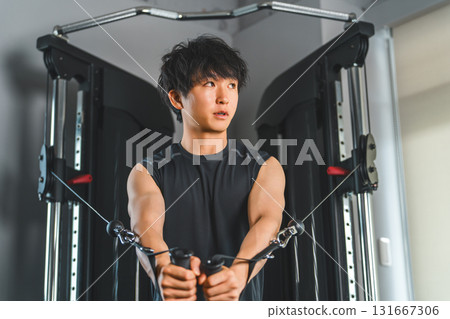 年輕的亞洲男子在健身房/訓練館使用動力架電纜進行胸肌訓練 131667306