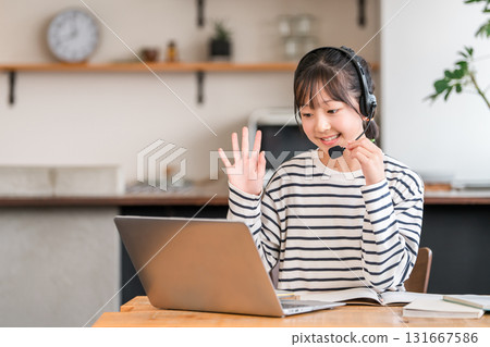 Elementary, junior high and high school students studying on a computer in the living room wearing intercoms and headsets 131667586