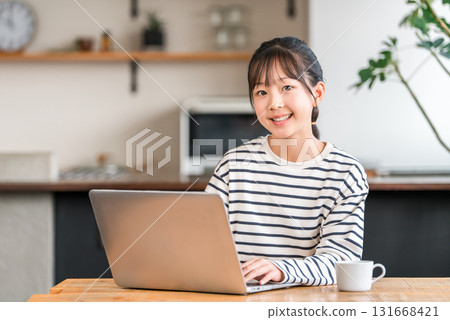 小學和國中女生在家中的客廳或學習角落使用電腦 131668421