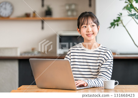 Elementary school and junior high school girls using a computer in the living room/study corner at home 131668423
