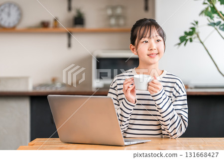 小學和國中女生在家中的客廳或學習角落使用電腦 小學和國中女生在家中的客廳或學習角落使用電腦 131668427