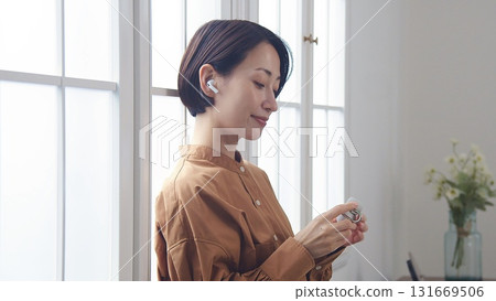 A woman listening to music or the radio by the window 131669506