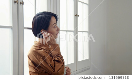 一位女士在窗邊聽音樂或聽收音機 131669518
