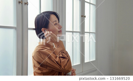 一位女士在窗邊聽音樂或聽收音機 131669520