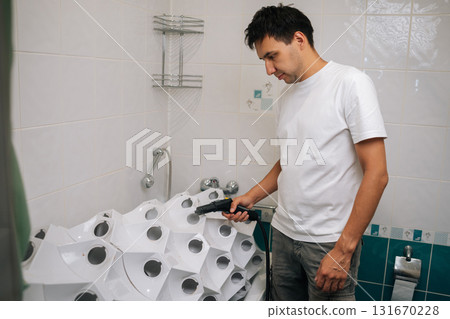 Focused young man sanitizing vertical hydroponic tower garden with steam cleaner in bathroom, highlighting innovative indoor gardening and cleaning technique. Concept of home gardening. Focused young man sanitizing vertical hydroponic tower garden with steam cleaner in bathroom, highlighting innovative indoor gardening and cleaning technique. Concept of home gardening. 131670228
