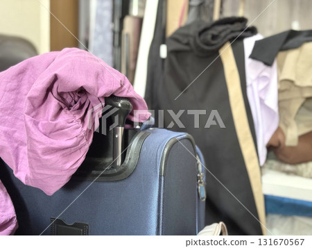 A woman's messy pink clothes and carry-on bag A woman's messy pink clothes and carry-on bag 131670567