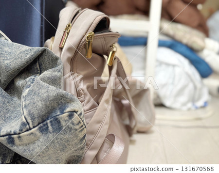 Pink backpack and jeans in a messy room 131670568