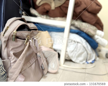 A pink backpack in a messy room 131670569