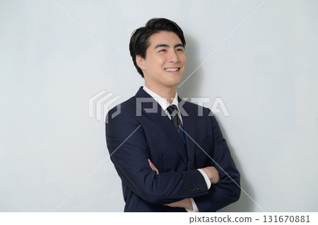 身穿西裝、雙臂交叉的男子，背景為白色 131670881