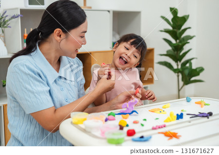 toddler girl with mother sculpting from plasticine at home toddler girl with mother sculpting from plasticine at home 131671627