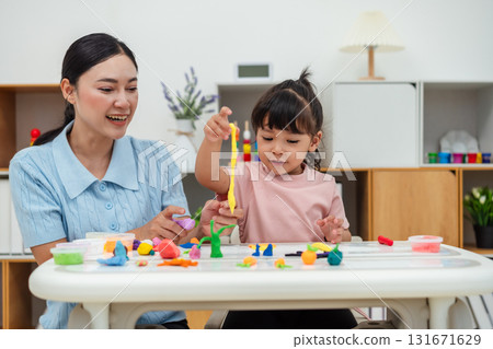 toddler girl with mother sculpting from plasticine at home toddler girl with mother sculpting from plasticine at home 131671629
