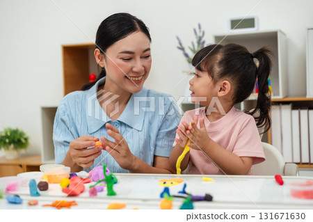 toddler girl with mother sculpting from plasticine at home 131671630