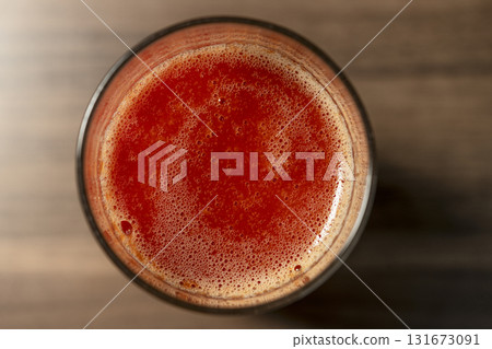 Glass of tomato juice with foam, top view Glass of tomato juice with foam, top view 131673091