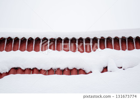 Thick White Snow on Red Roof with Subtle Icicles in Winter Thick White Snow on Red Roof with Subtle Icicles in Winter 131673774