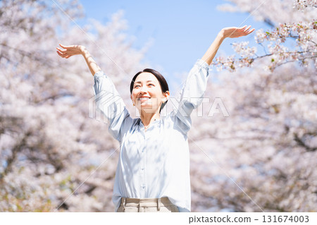 Young woman stretching under a cherry tree Lifestyle image 131674003