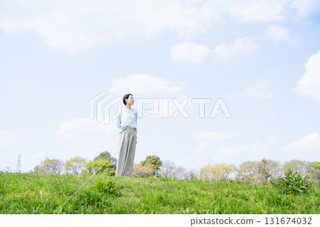 年輕女子在綠色山丘上放鬆生活方式圖像 131674032