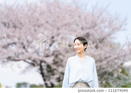 Young woman posing in front of a cherry blossom tree Lifestyle image Young woman posing in front of a cherry blossom tree Lifestyle image 131674040