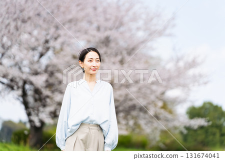 Young woman posing in front of a cherry blossom tree Lifestyle image 131674041