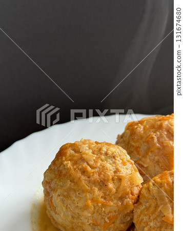 Three steaming meatballs with sauce on plate. Meatballs with rice and onions simmered in tomato sauce. Delicious and healthy home cooking. 131674680