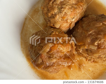 Three steaming meatballs with sauce on plate. Meatballs with rice and onions simmered in tomato sauce. Delicious and healthy home cooking. Three steaming meatballs with sauce on plate. Meatballs with rice and onions simmered in tomato sauce. Delicious and healthy home cooking. 131674686