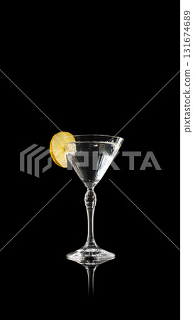 Transparent martini drink with lemon slice on black reflection Transparent martini drink with lemon slice on black reflection 131674689
