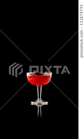 Red cocktail in crystal glass on reflective black background Red cocktail in crystal glass on reflective black background 131674735