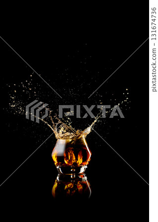 Whiskey splash captured in dynamic motion with amber reflections Whiskey splash captured in dynamic motion with amber reflections 131674736