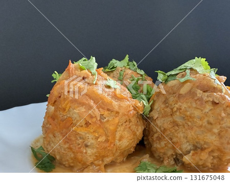 Meatballs with rice and onions simmered in tomato sauce. Delicious and healthy home cooking. 131675048