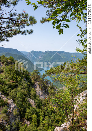 Canyon river meandering among green forested mountains, nature landscape photography under blue sky Canyon river meandering among green forested mountains, nature landscape photography under blue sky 131675058