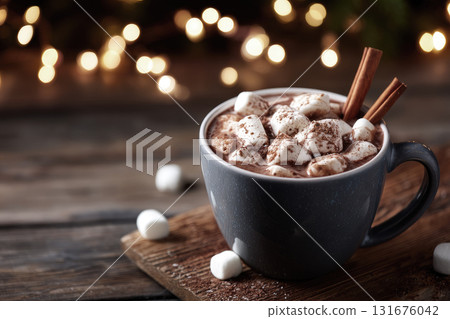Cup of hot chocolate with marshmallows and cinnamon sticks on rustic wooden table, Christmas lights blurred in background Cup of hot chocolate with marshmallows and cinnamon sticks on rustic wooden table, Christmas lights blurred in background 131676042
