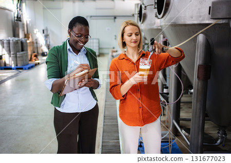Brewery women performing quality control during beer production Brewery women performing quality control during beer production 131677023