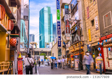 Tokyo cityscape in Japan. View of the bars in front of Shimbashi Steam Locomotive Square. In the background are Shimbashi Station and the Shiodome buildings. (October 2nd) 131677809