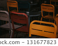 Colorful yellow, red chairs at a cafe. A close-up shot of several colorful chairs arranged around tables. Outdoor cafe setting with empty sits. 131677823