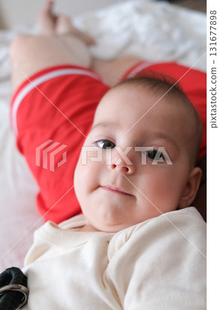 Adorable Baby Close-Up with Red Shorts Background 131677898
