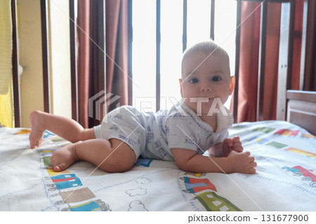 Baby Crawling in Crib with Colorful Bedspread Baby Crawling in Crib with Colorful Bedspread 131677900