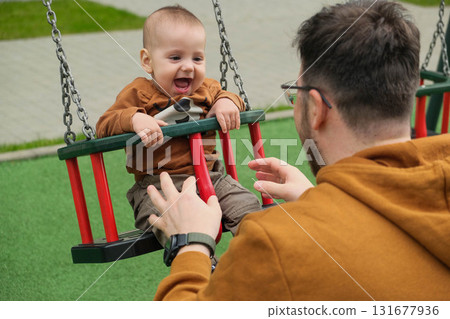 Father and Baby Enjoying Swing Time 131677936