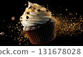 One chocolate muffin fresh baked. Dark cupcake falling mid-air. Sweet vanilla frosting falls on black background. Crumbs flying and chocolate shards golden sprinkles fly. Dynamic sweet dessert shot. 131678028